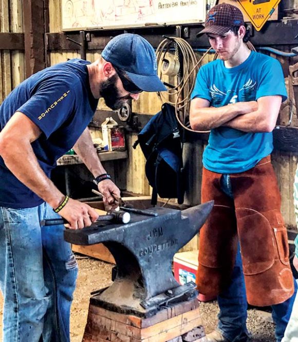 A farrier works on a shoe with an anvil. 